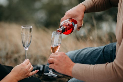 Person Pouring Champagne in Champagne Flute