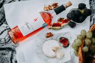 精致的野餐以玫瑰葡萄酒、奶酪、无花果和核桃为特色