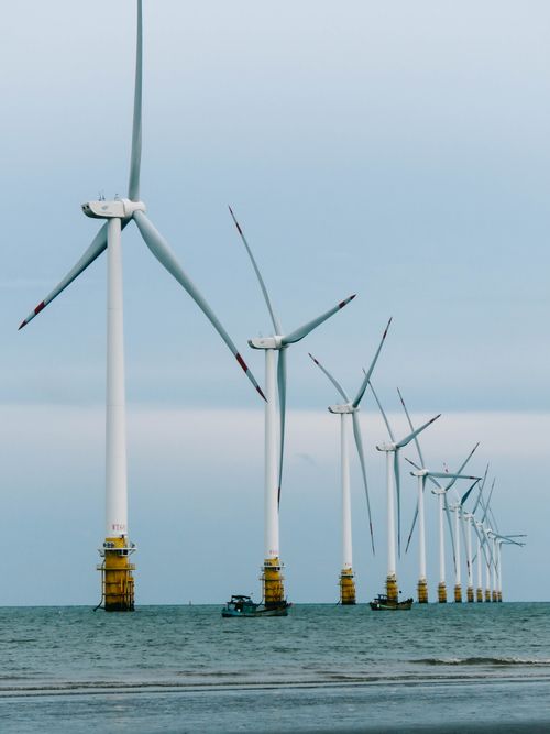 Free Rows of offshore wind turbines harnessing renewable energy in the ocean. Stock Photo