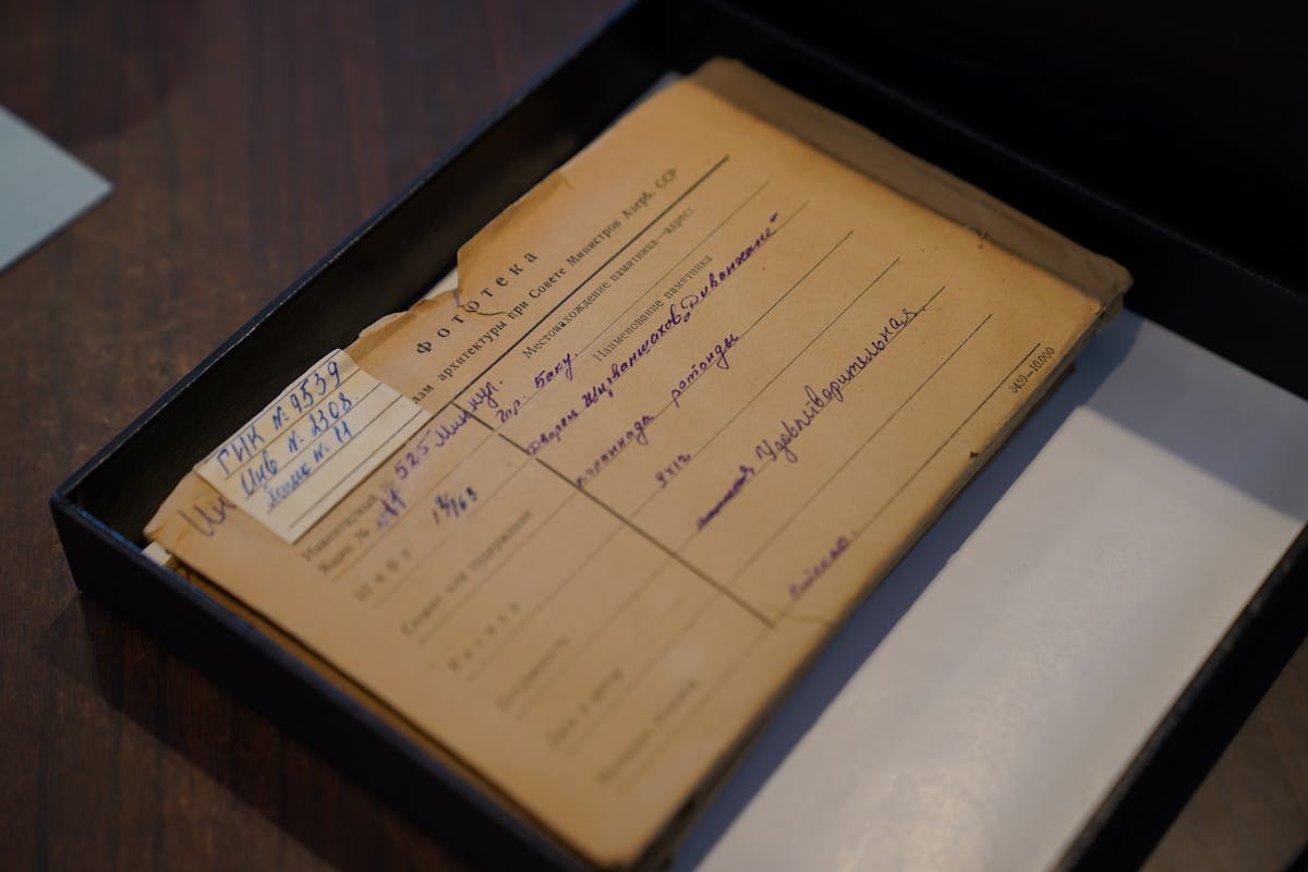 Documento d'archivio ingiallito all'interno di una scatola su una scrivania