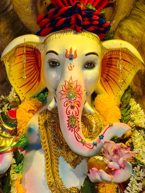 Free Colorful statue of Lord Ganesha adorned with intricate designs and flowers, capturing divine elegance. Stock Photo