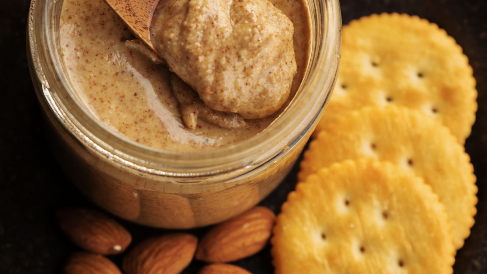 A jar of creamy almond butter with a wooden spoon and whole almonds — photo by cole yap on Pexels A jar of creamy almond butter with a wooden spoon and whole almonds
