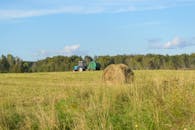 Tractor and Hay Bale in Serene Field Landscape