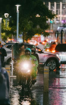 Rainy night scene in Jakarta with motorbikes and urban traffic, capturing vibrant city life.