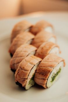 Close-up of exquisite salmon sushi rolls served on a white plate, perfect for food lovers.