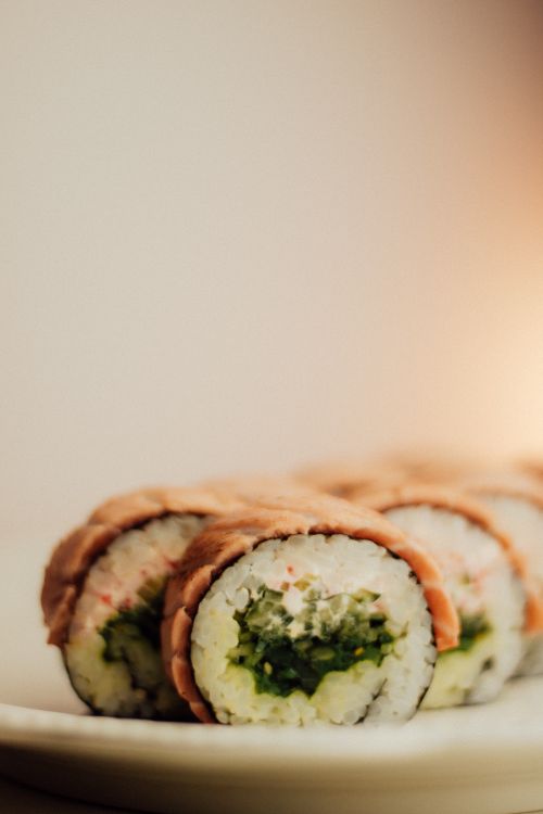 Free Close-up of sushi roll with fresh rice and greens on a plate, perfect for food lovers. Stock Photo