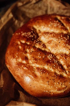 Close-up of rustic homemade bread with sesame seeds, freshly baked on craft paper.
