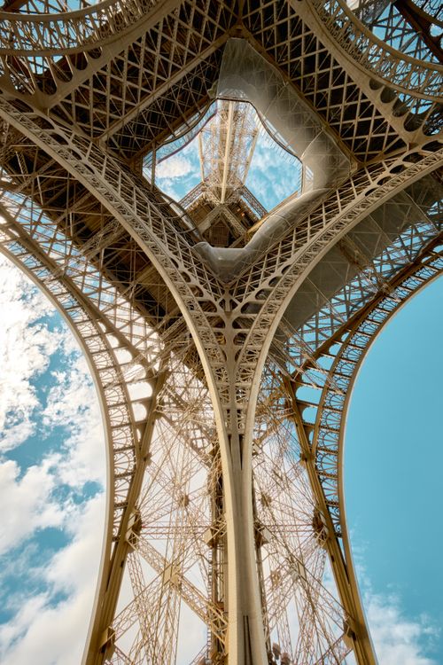 Free A captivating upward view of the Eiffel Tower showcasing the intricate ironwork against a clear sky. Stock Photo