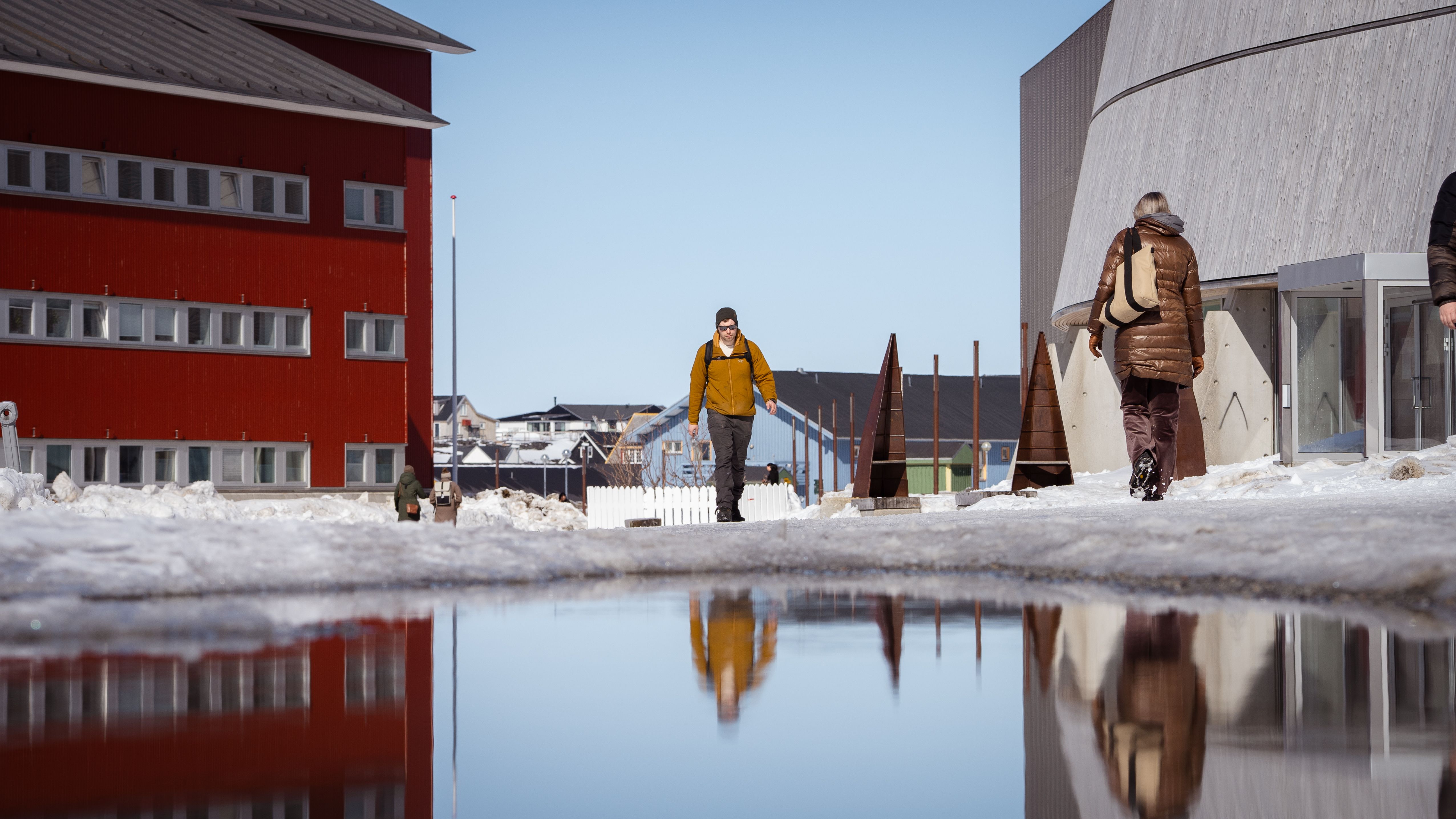 Winter scene in Nuuk, Greenland with modern architecture and reflections in water.