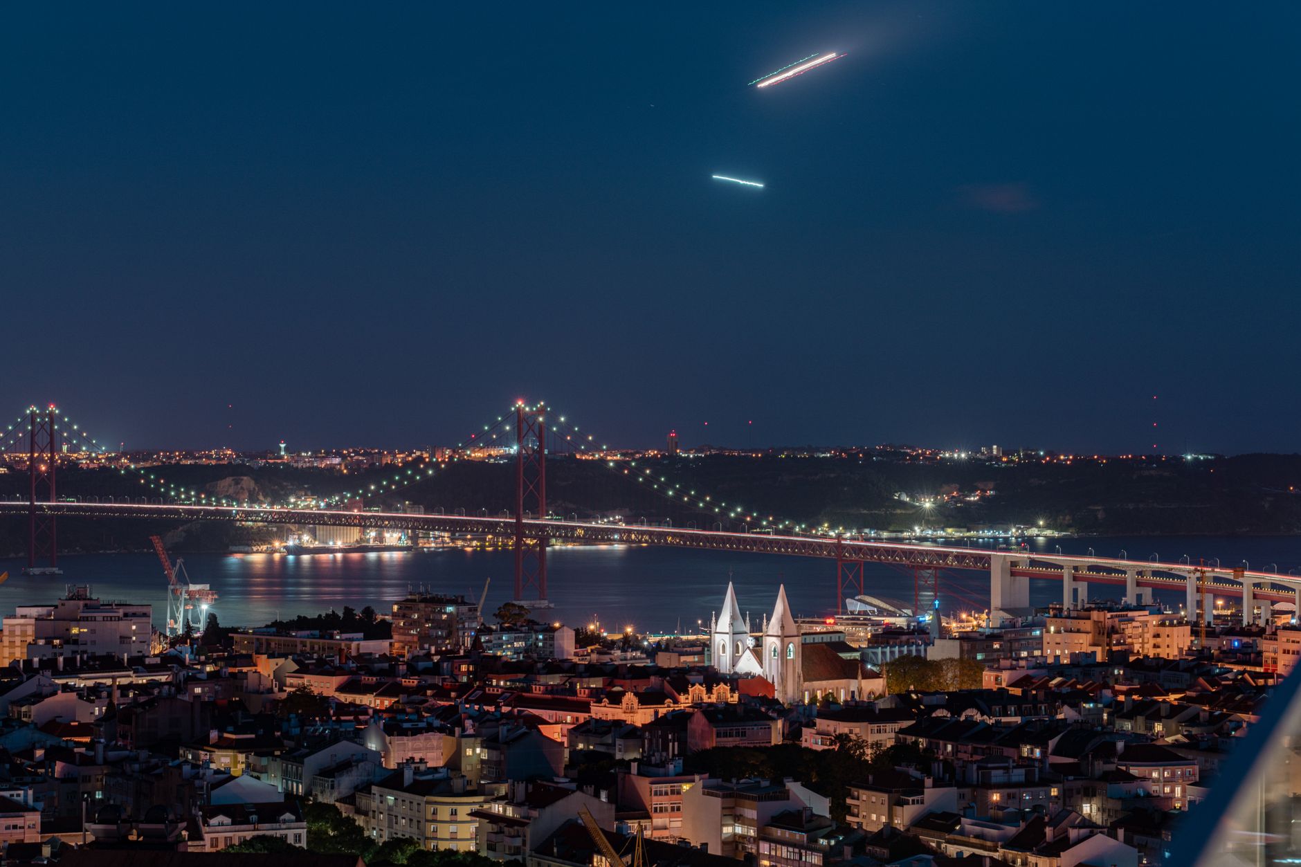 Mesa de jantar elegante à luz de velas com vista noturna sobre a cidade de Lisboa