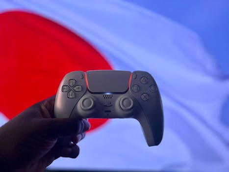 A PlayStation 5 DualSense controller is held up against a backdrop of the Japanese flag.