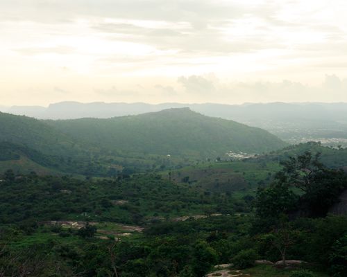 Free A tranquil landscape of lush green hills under a cloudy sky, perfect for nature enthusiasts. Stock Photo