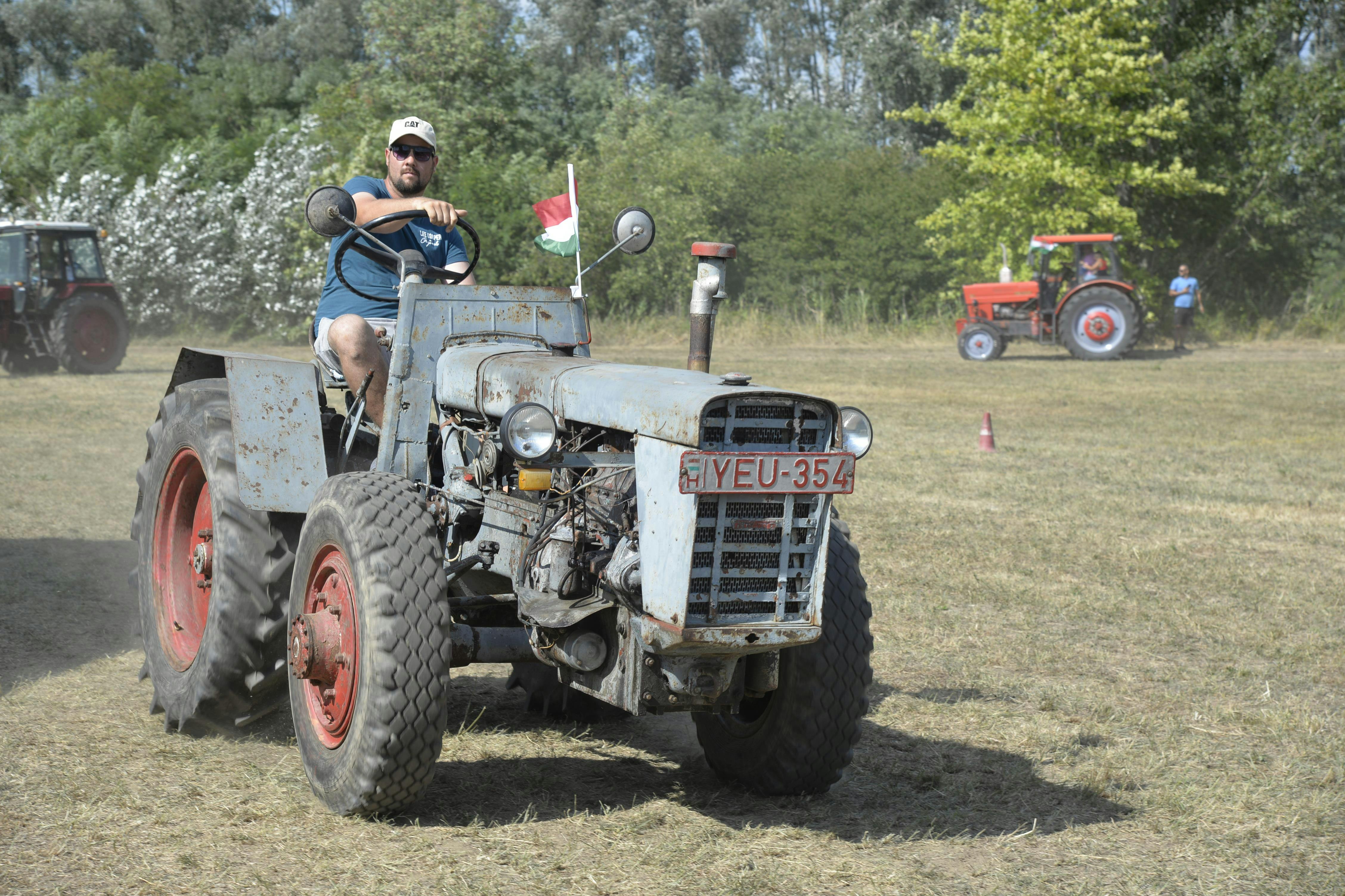 A man driving an old tractor during a rural event in Tunyogmatolcs, Hungary.