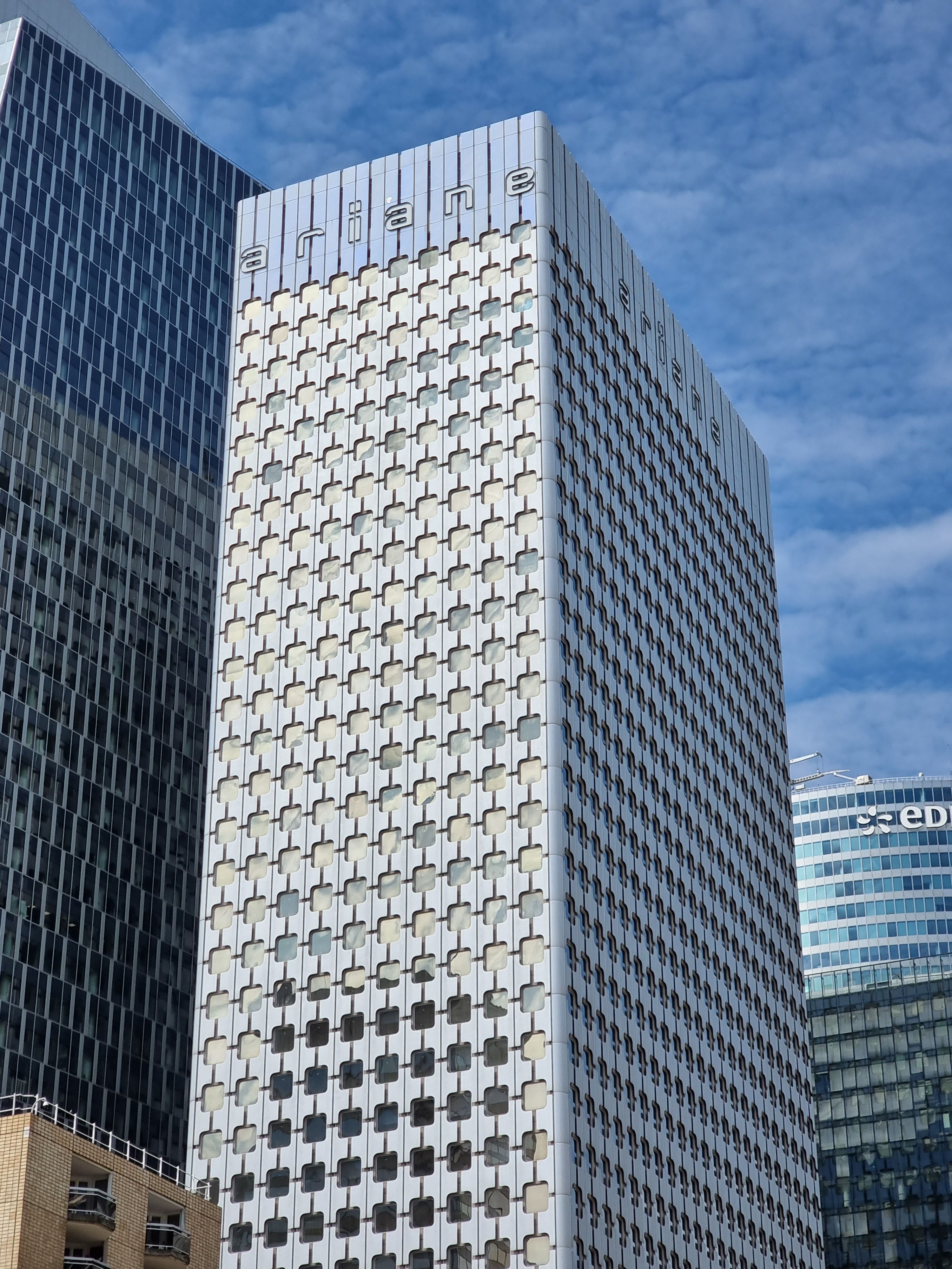 View of the Ariane Tower in La Défense, Paris, under a blue sky.