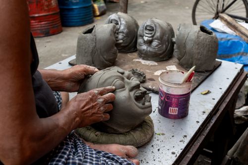 Free Artisan crafting clay head for Durga Puja in Kolkata, India, highlighting traditional sculpture skills. Stock Photo