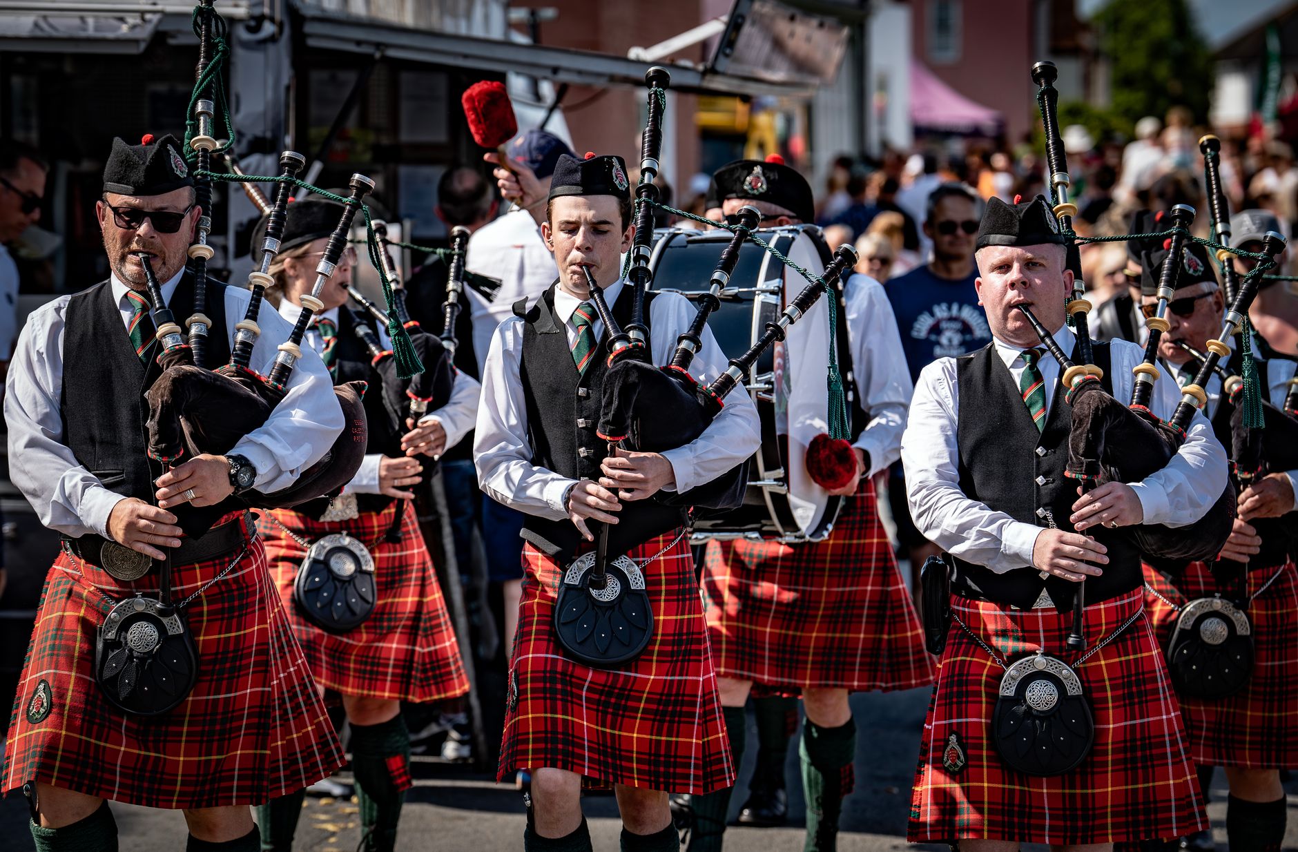 Highland Festival Mount Dora: A Local's Guide to the Scottish Weekend (February 2026) 2 Traditional Scottish bagpipers in kilts performing at a lively outdoor event in the UK.