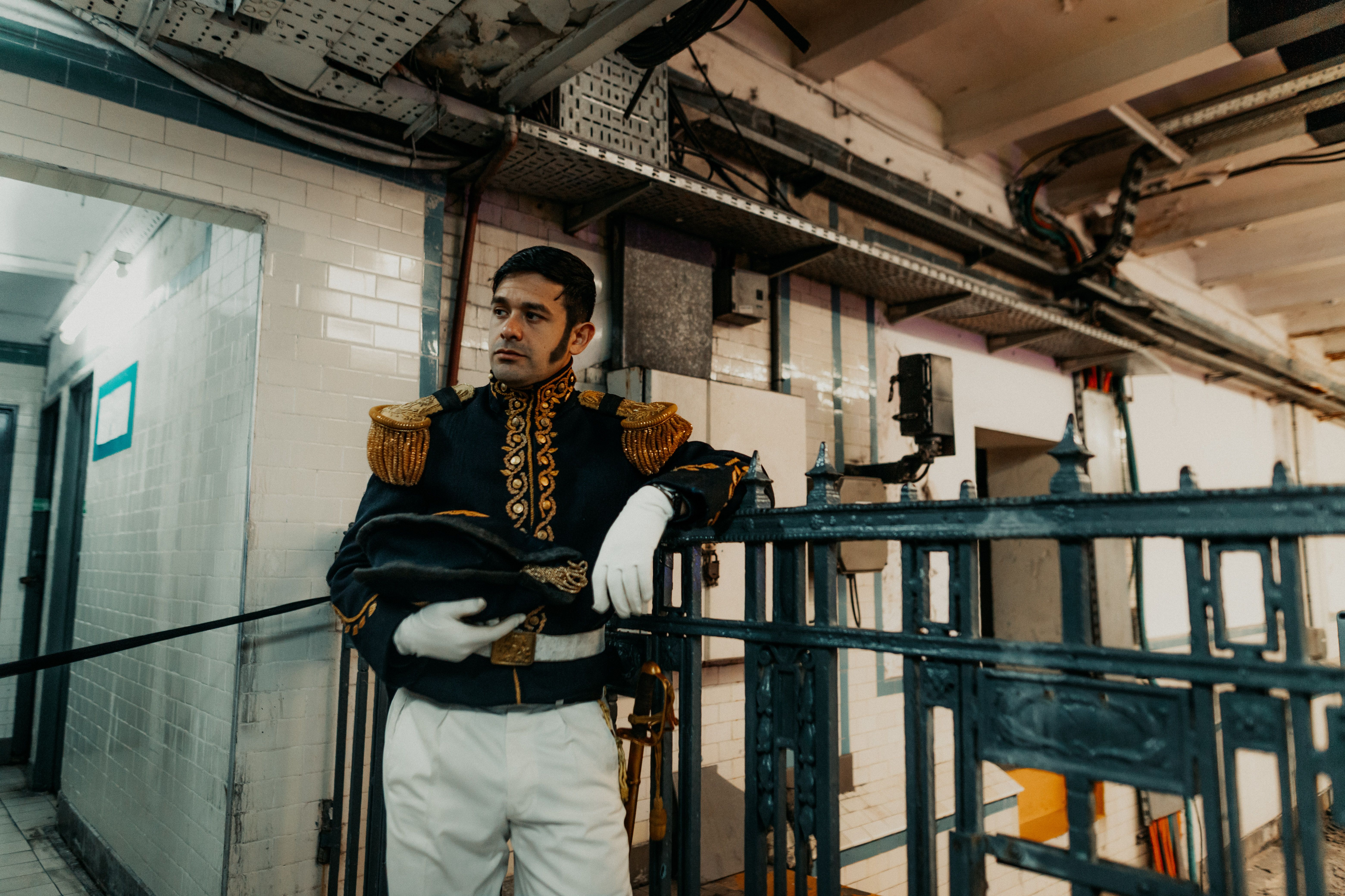 Man in ornate costume in Buenos Aires reflects historical elegance indoors.