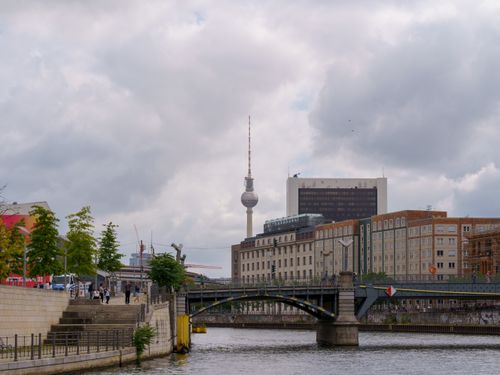 Free A vibrant cityscape of Berlin with the iconic TV Tower and Spree River under a cloudy sky. Stock Photo