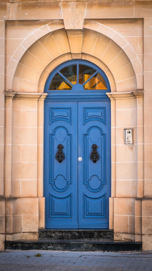Free A vibrant blue arched doorway showcasing classic European architectural charm and detail. Stock Photo
