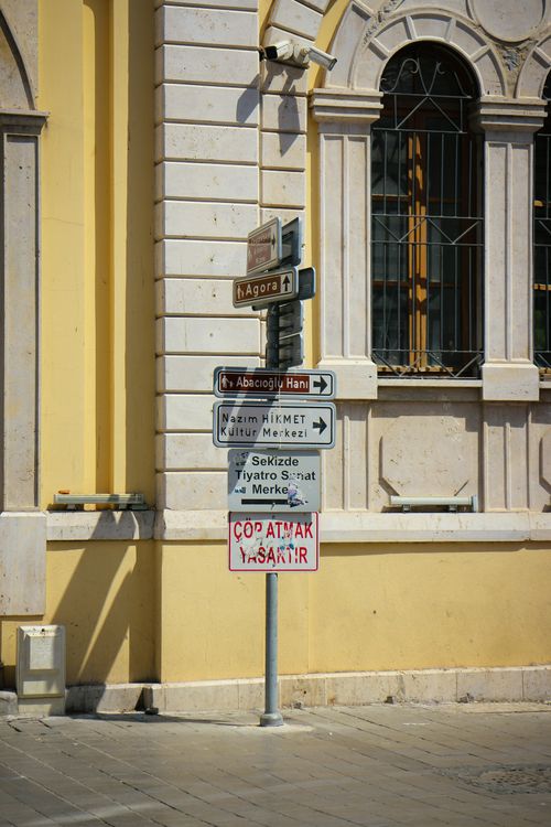 Free A street sign near a historic building facade under sunlight, ideal for urban and travel themes. Stock Photo