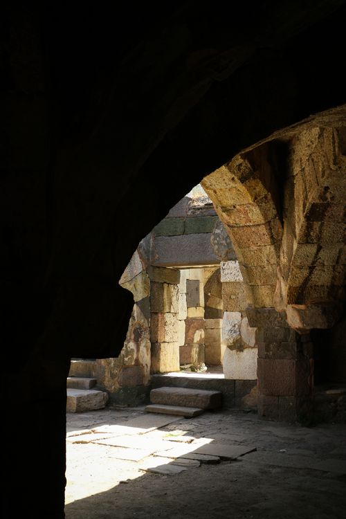 Free Explore the interior of an ancient stone structure featuring a sunlit archway and rustic textures. Stock Photo