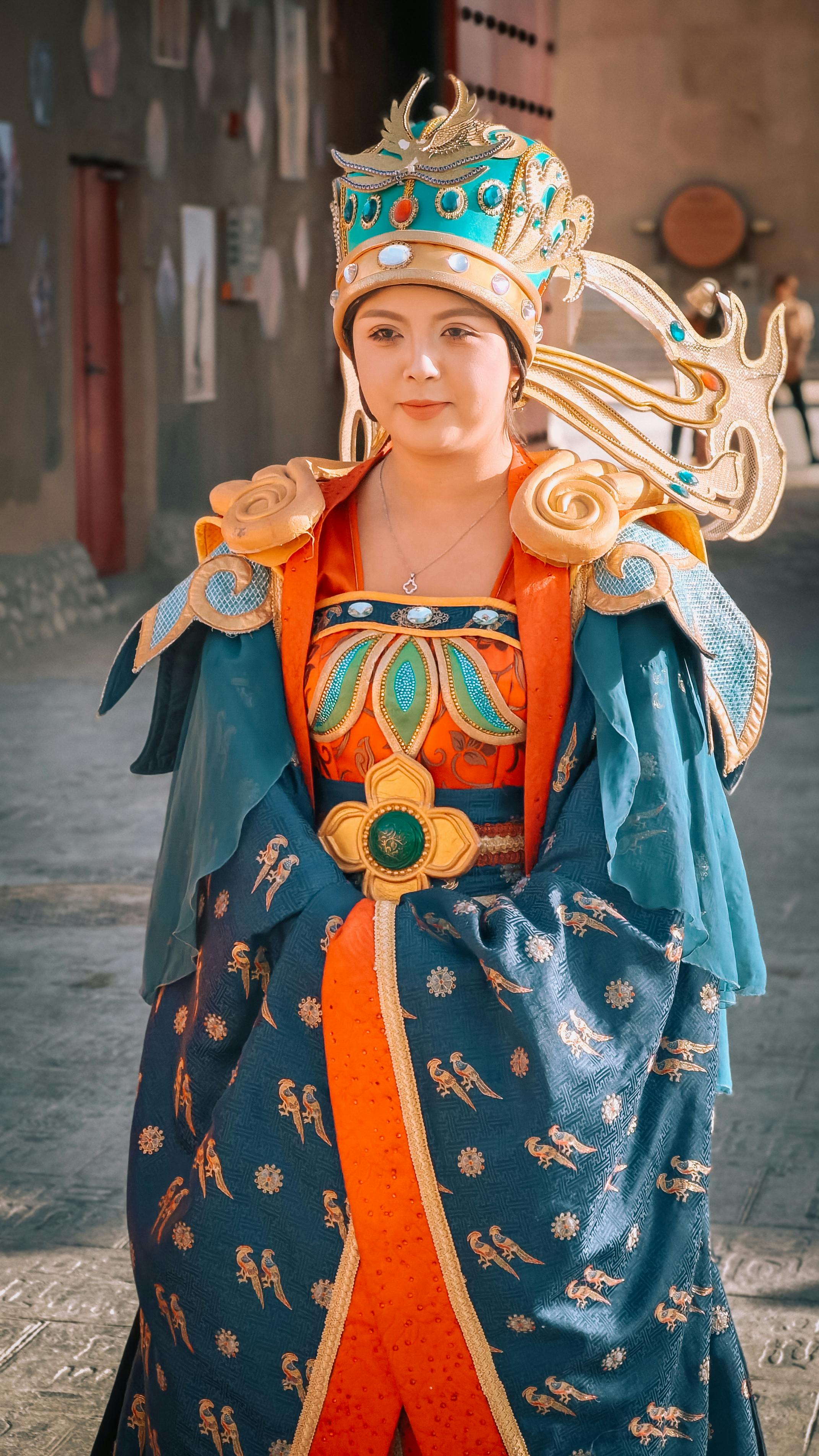 Woman in elaborate traditional Chinese attire outdoors, showcasing cultural heritage.
