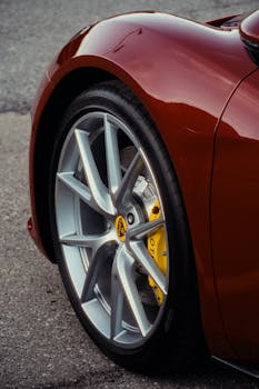 Stunning close-up of a red vintage car wheel highlighting alloy and brake caliper details.
