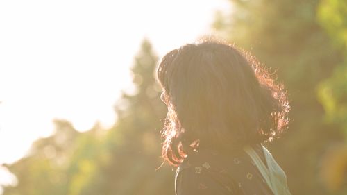 Free Silhouette of a woman in sunlight with nature background, conveying tranquility. Stock Photo