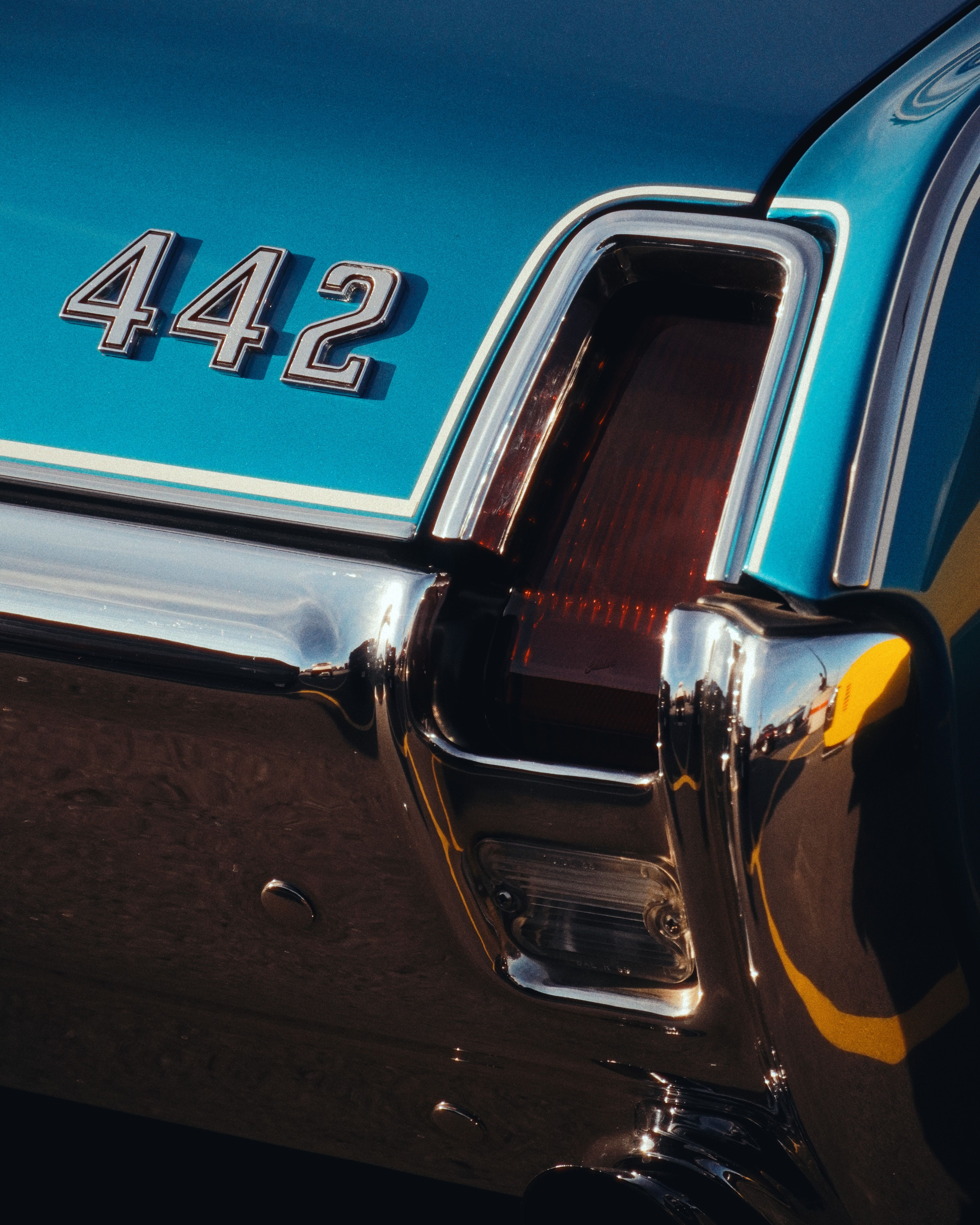 grátis Uma foto detalhada da traseira de um carro clássico com o emblema 442, exibindo o design vintage e os detalhes cromados. Foto profissional