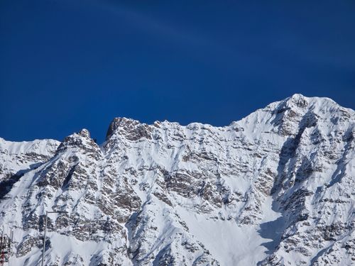 Free Breathtaking view of snow-covered mountain peaks under a clear blue sky. Stock Photo