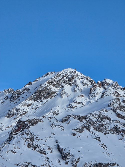 Free Pristine snow-covered mountain peak against a clear blue sky, perfect for winter-themed projects. Stock Photo