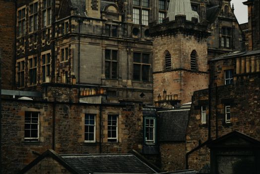 An atmospheric view of historic stone buildings with gothic architecture at dusk, showcasing intricate brickwork.