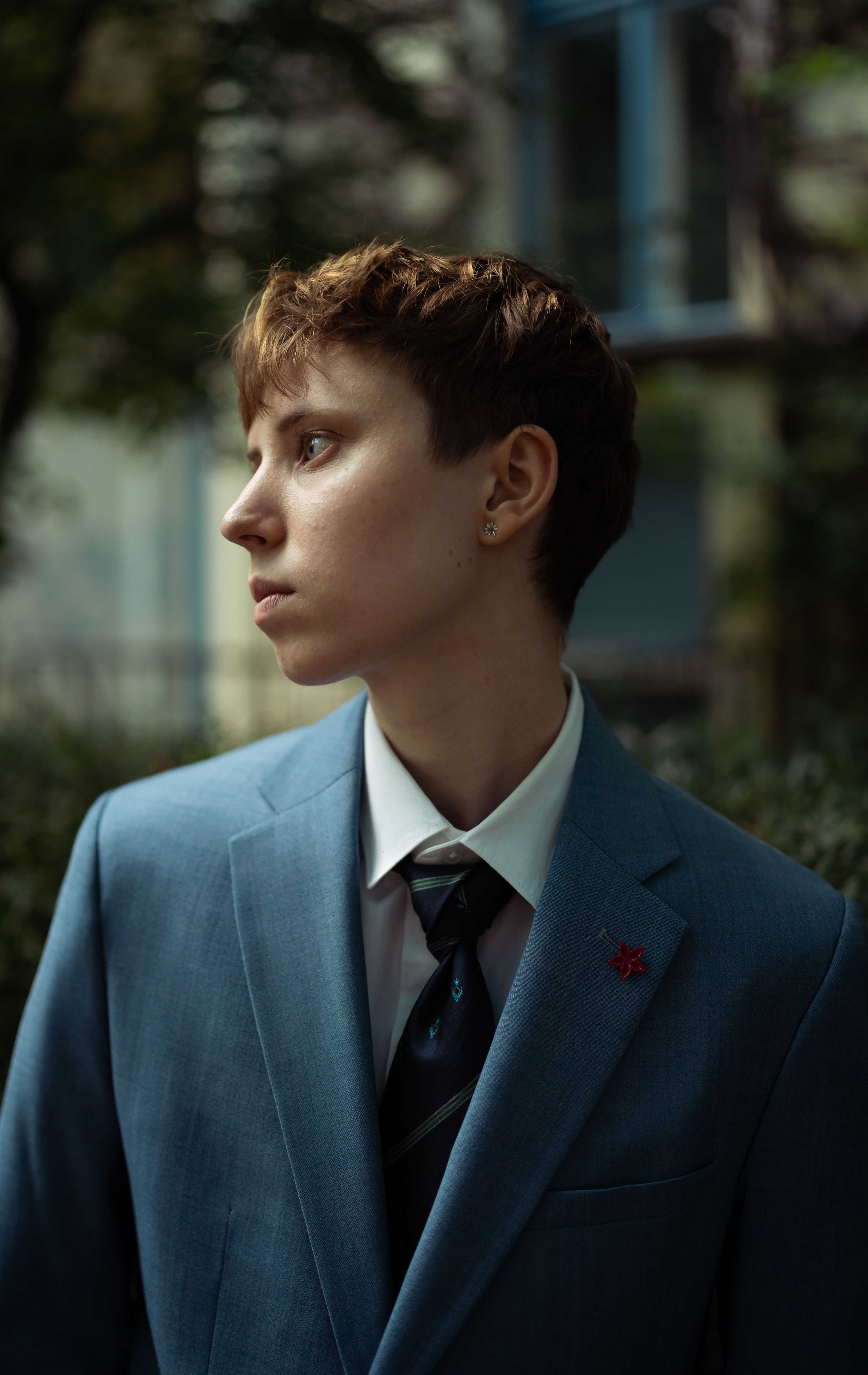 Stylish young adult in blue suit posing outdoors in Berlin, showcasing fashion and elegance.