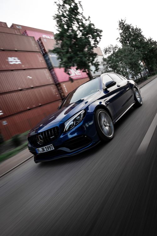 Free Powerful Mercedes car in motion near shipping containers in Hamburg, Germany. Stock Photo