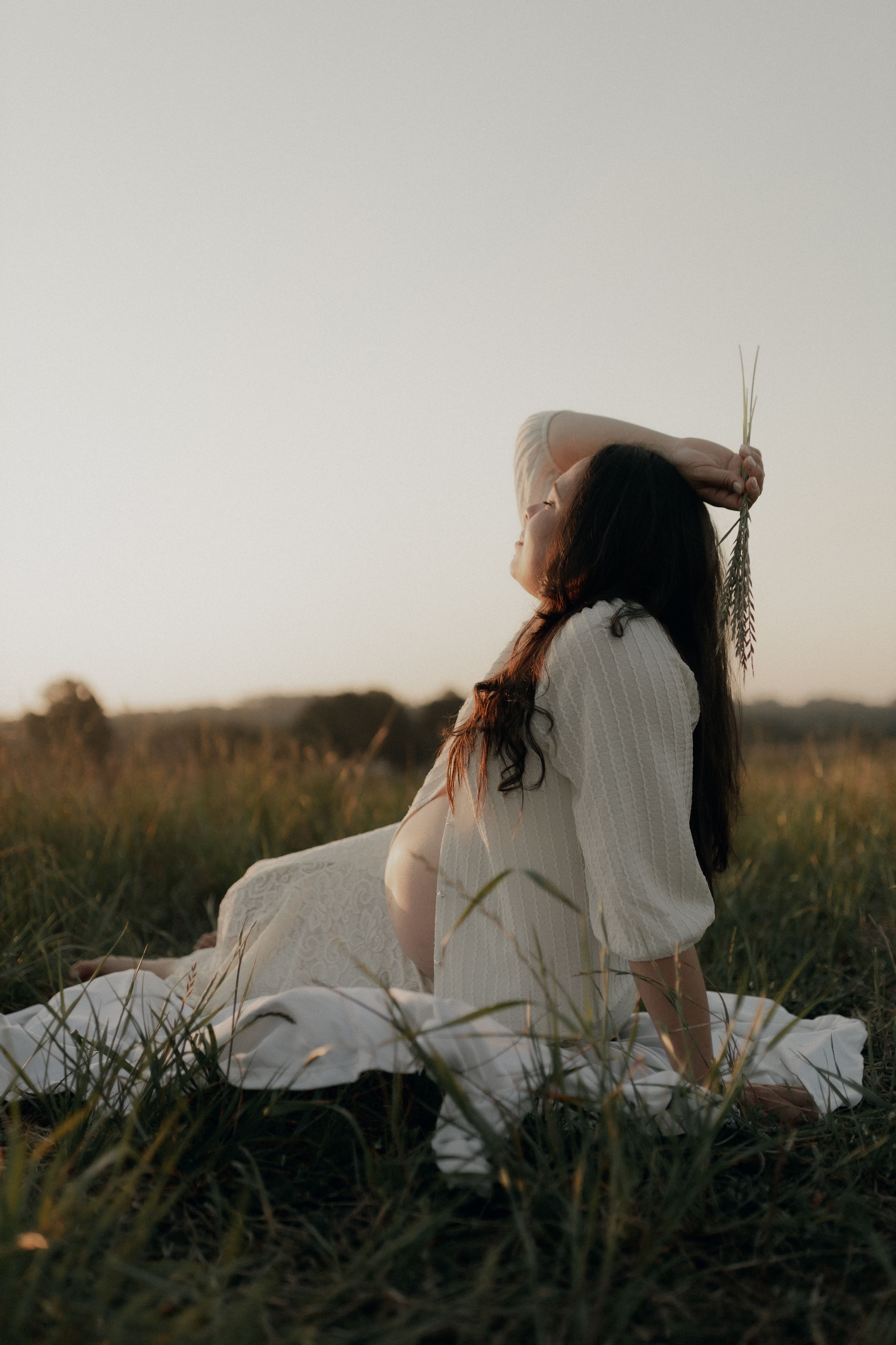 Woman in White Long Sleeve Shirt Sitting on Green Grass Field · Free ...