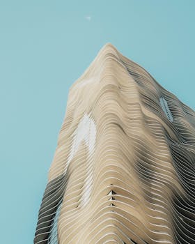 A modern skyscraper with unique wave-like design against a clear blue sky in Chicago.