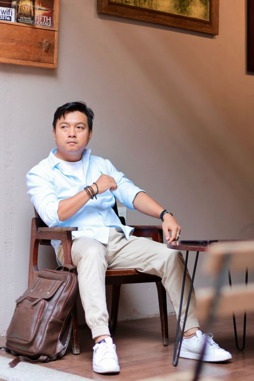 Free A thoughtful man sitting in a cafe, exuding a relaxed, casual vibe. Stock Photo