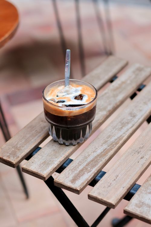 Free Close-up of iced coffee with cream on rustic wooden table, outdoors. Stock Photo
