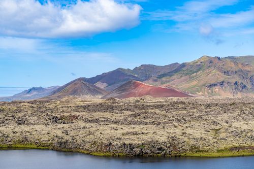 Free A stunning view of Iceland's lava fields and colorful mountains under a blue sky. Stock Photo