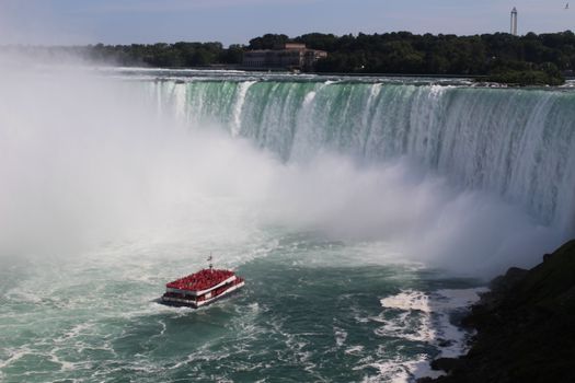 Tour boat approaching the stunning Niagara Falls, Ontario, Canada.