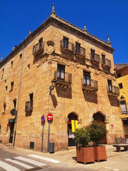 A beautiful historic stone building under a clear blue sky, showcasing intricate architecture.