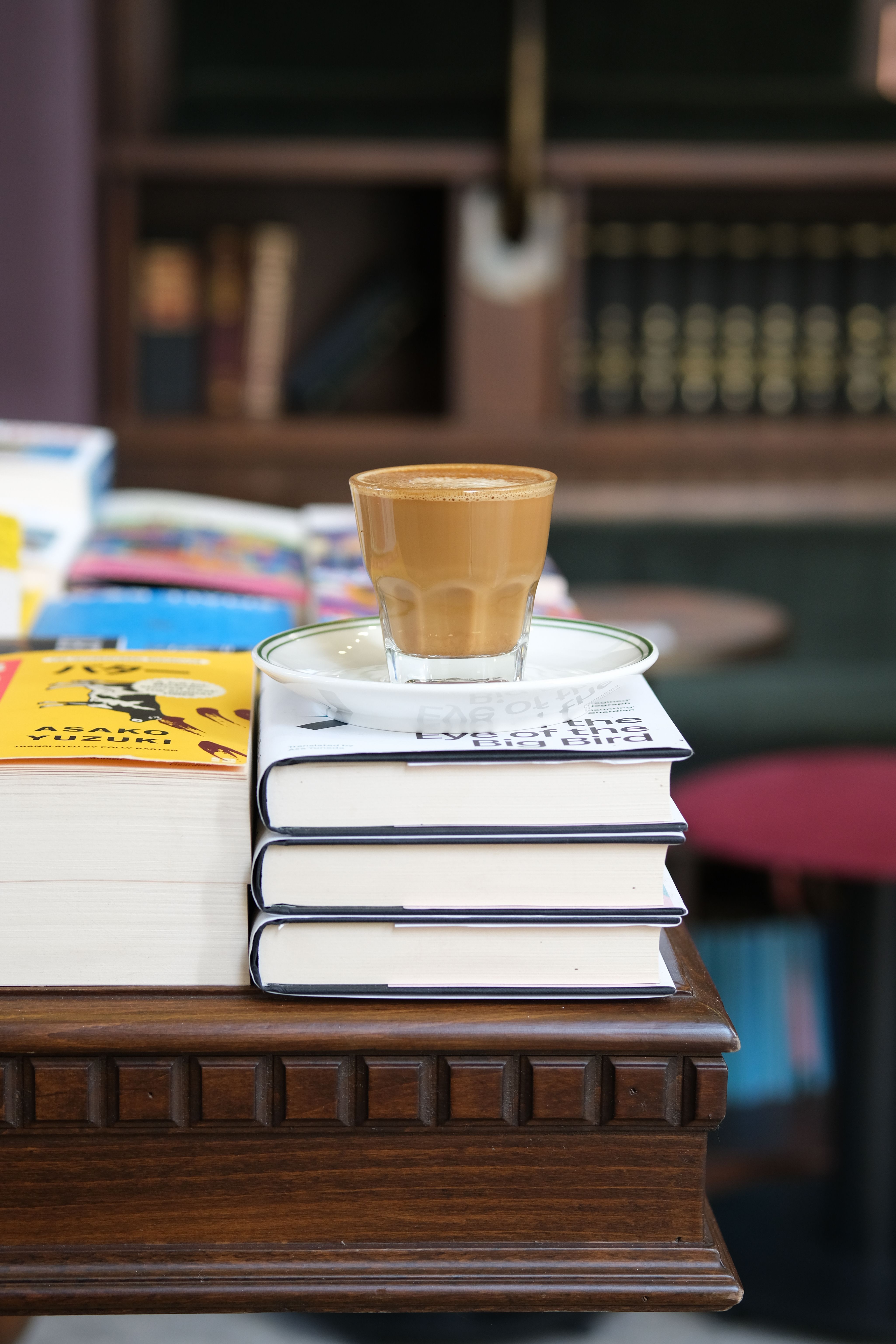stacked hardcover books in a corner used as a temporary small coffee bar surface