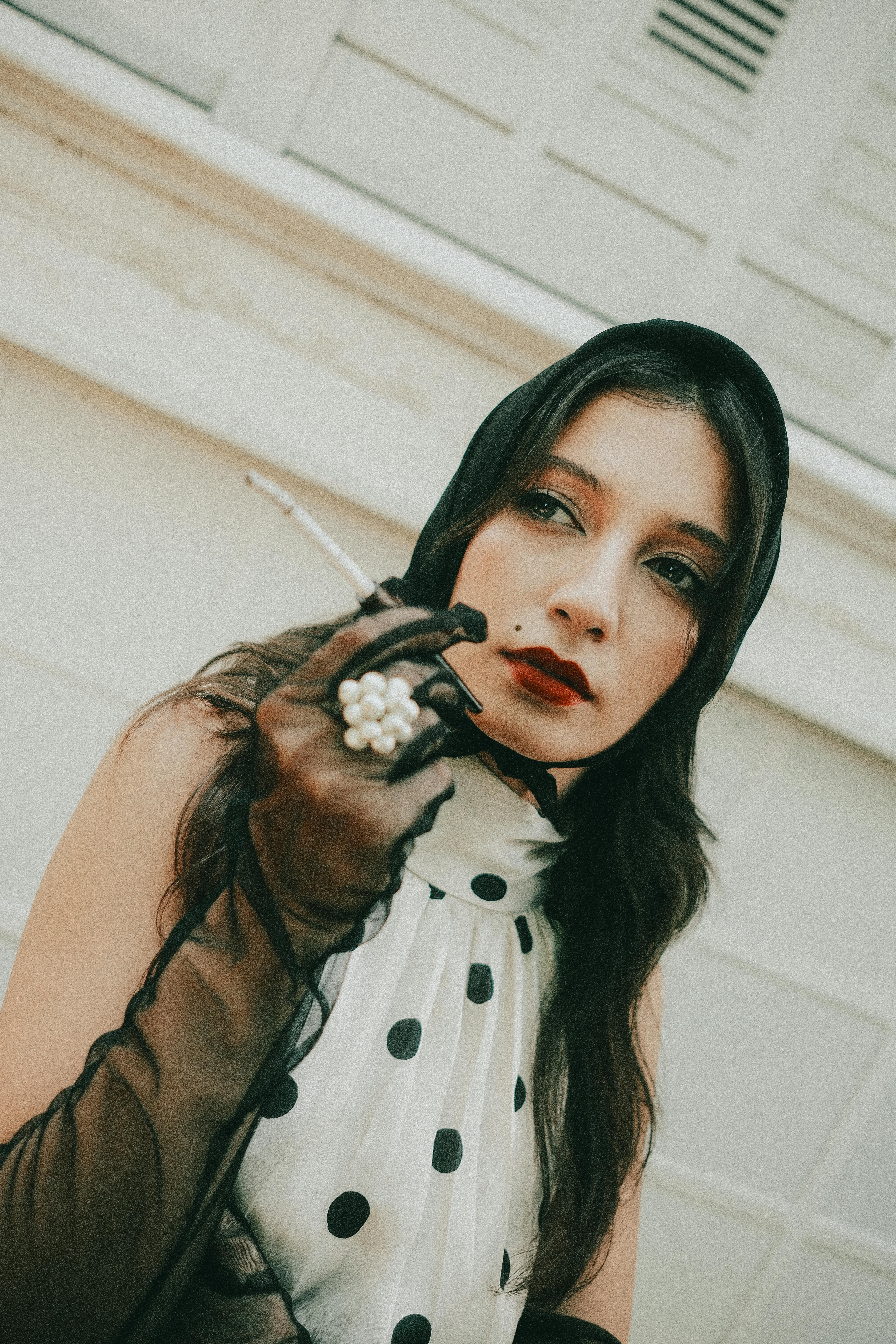Free Portrait of a woman in polka dot dress and gloves, exuding vintage elegance. Stock Photo