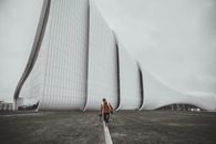 一名男子在阿塞拜疆巴库的海达尔·阿利耶夫中心现代建筑旁漫步
