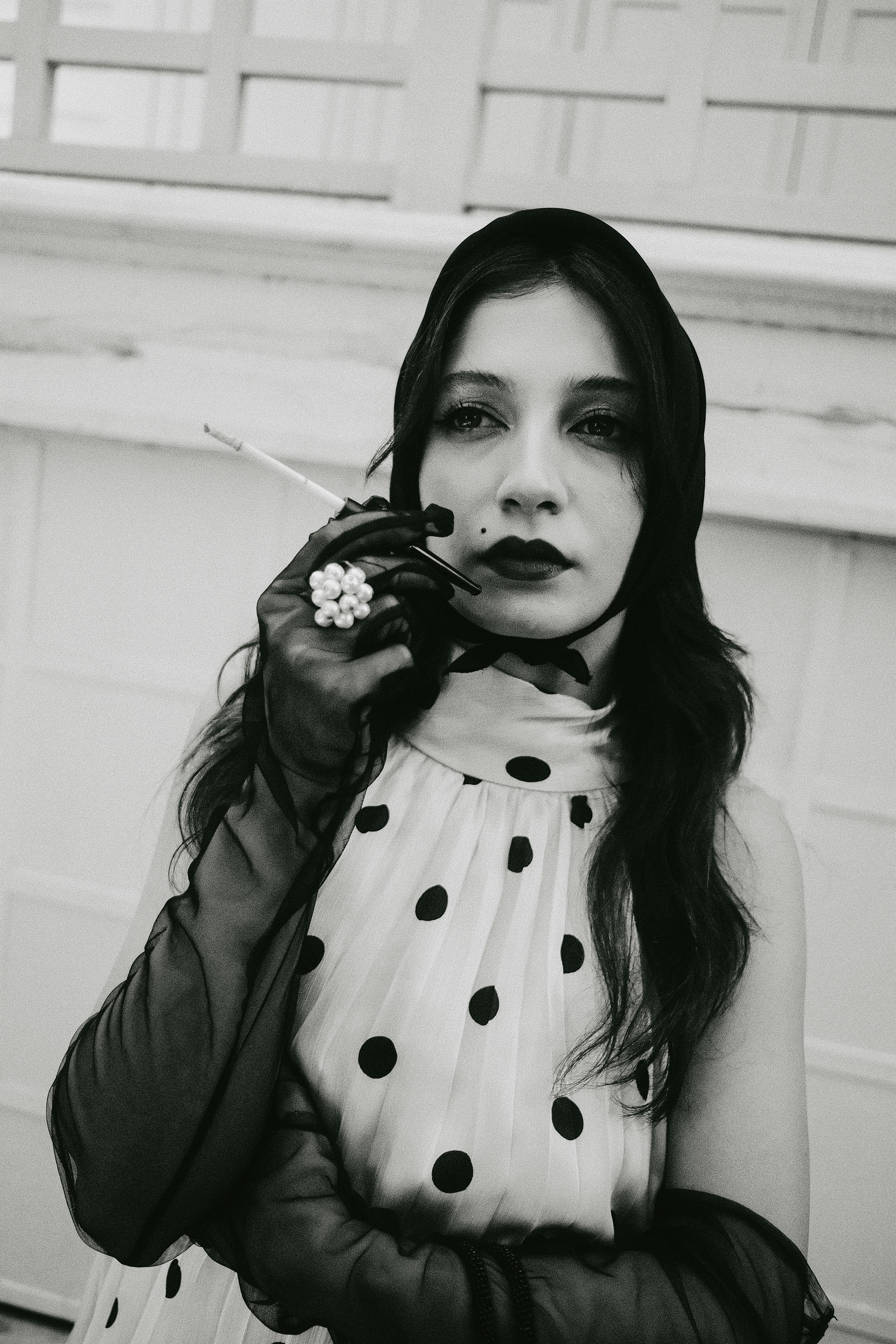 Free Black-and-white portrait of a woman in vintage polka dot dress, capturing classic elegance. Stock Photo