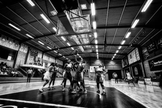 Dramatic indoor basketball game scene in Johannesburg, capturing athletes competing intensely under bright lights.