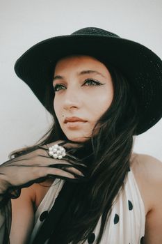 Stylish woman wearing a black hat and gloves, embodying classic vintage fashion.