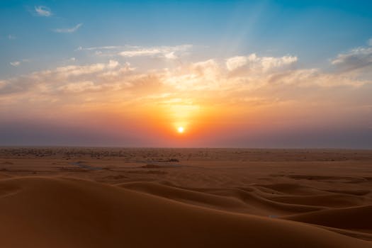 Experience the vibrant sunset over Dubai's endless sand dunes, capturing the essence of serene desert beauty.