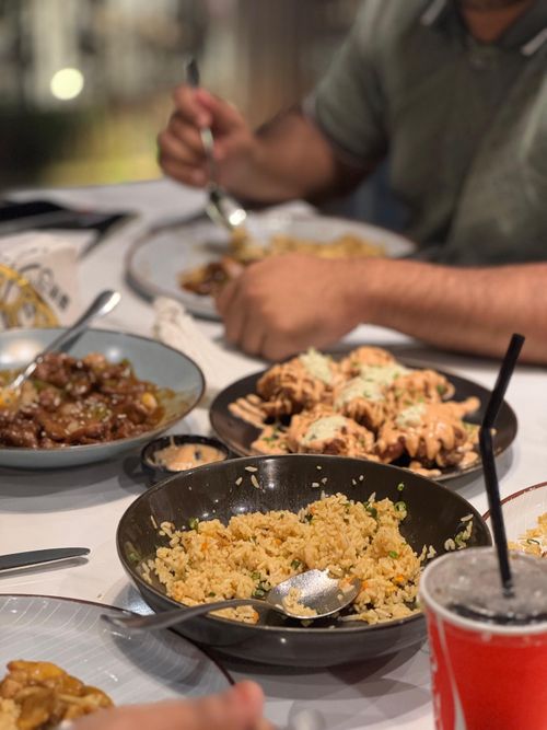 Free A vibrant table scene showcasing Asian dishes being enjoyed by friends. Stock Photo
