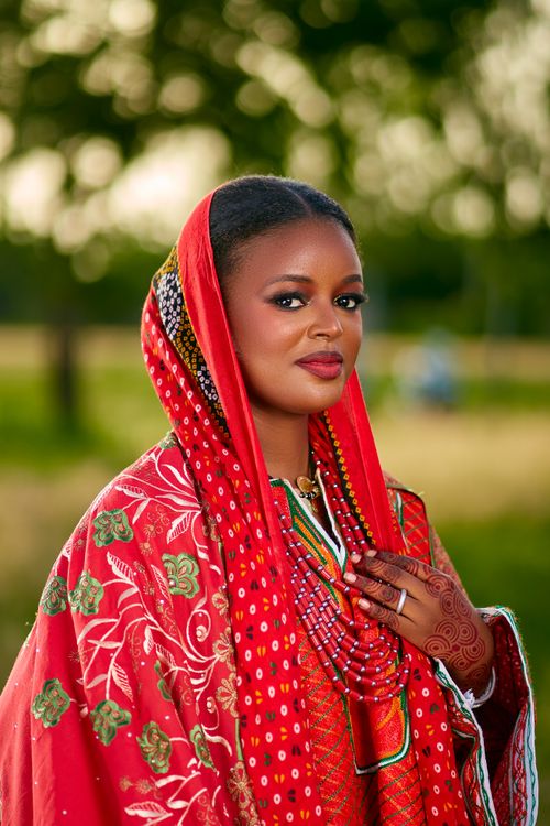 Free Stunning woman in red traditional dress with henna, outdoors. Stock Photo